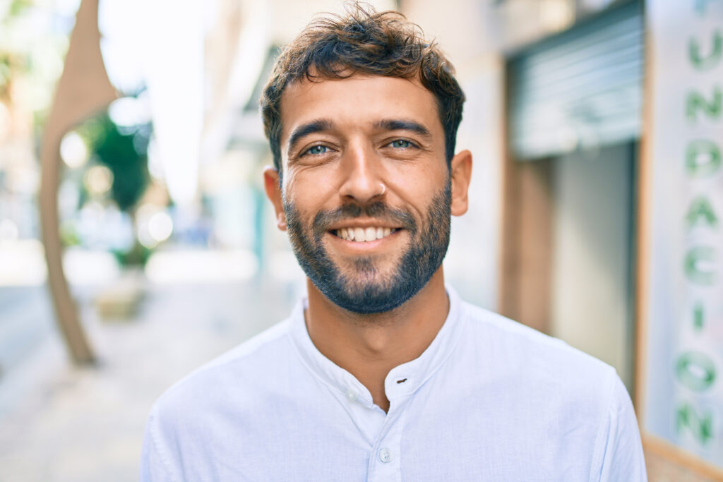 Smiling bearded man in a white shirt