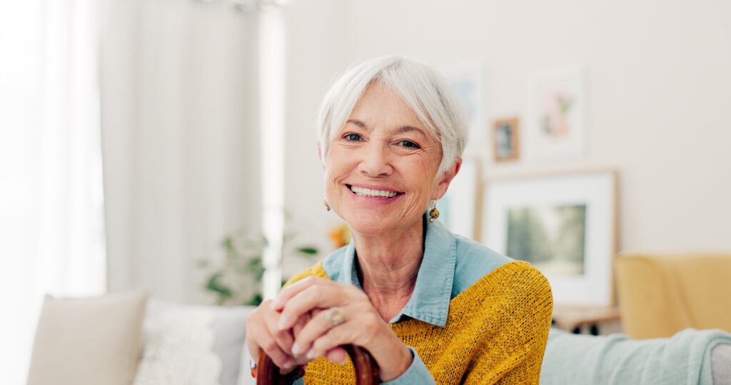 Smiling older woman with white hair seated at home