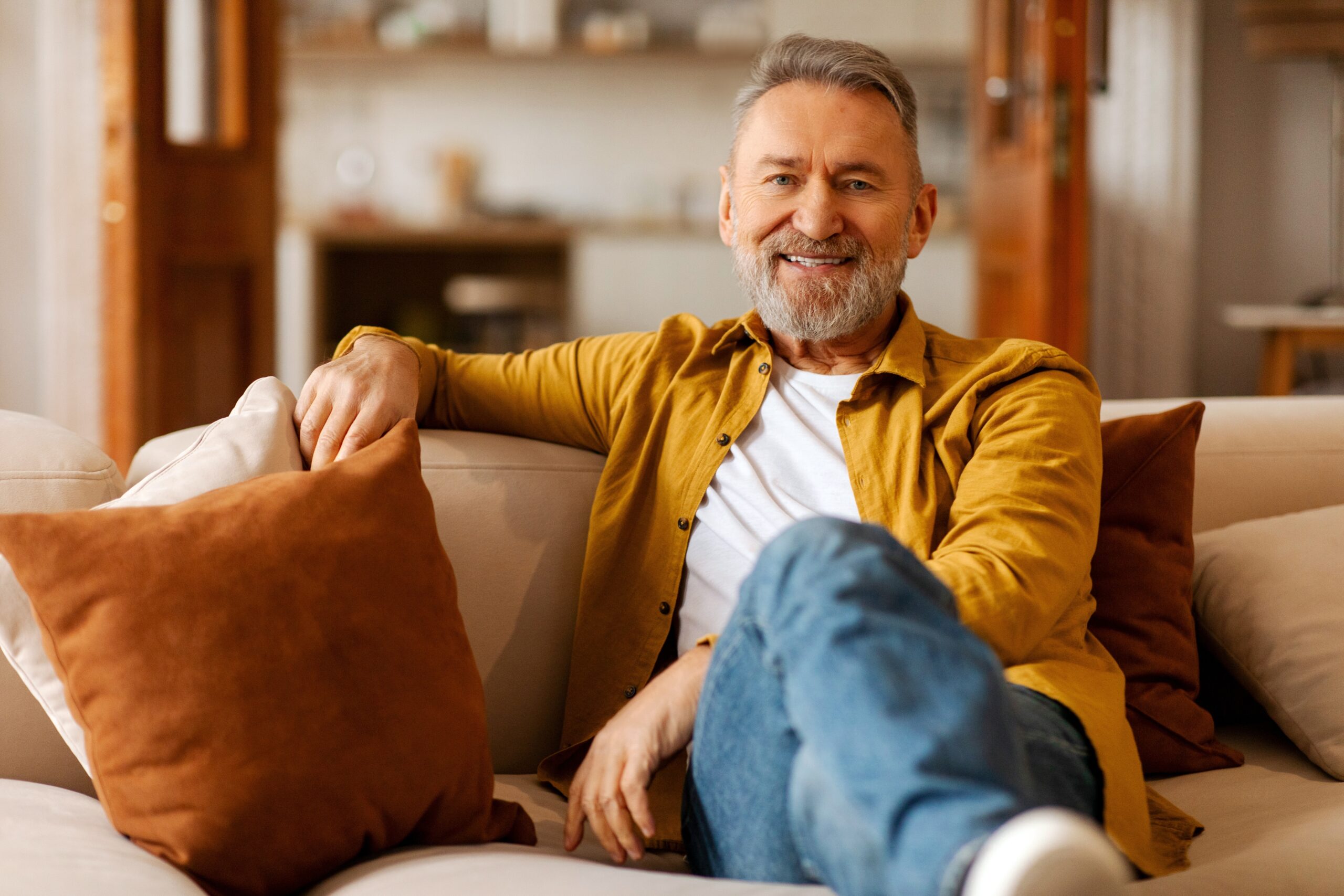 Smiling older man relaxing on a sofa