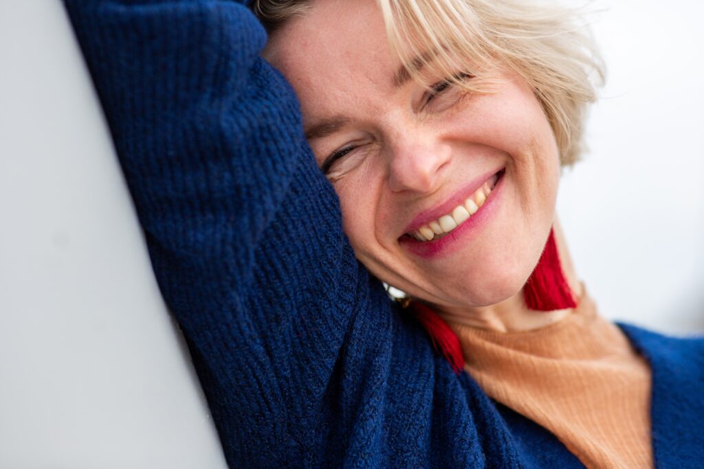 Smiling woman leaning on a sofa cushion
